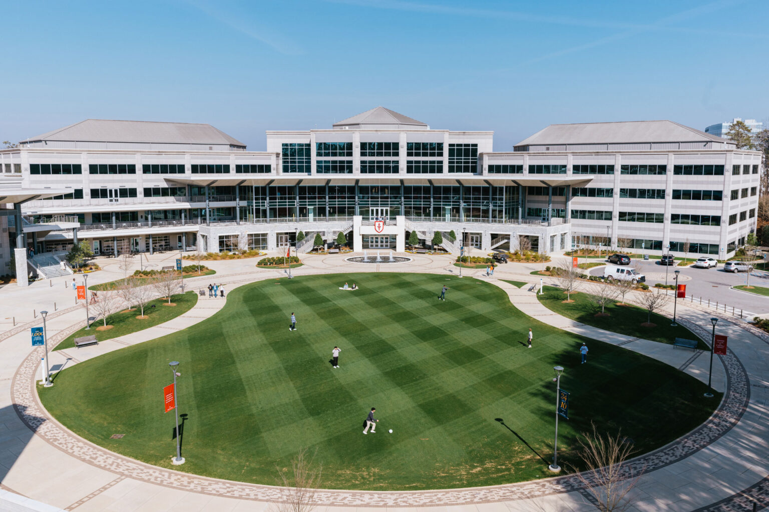 undergraduate students sitting and laughing on campus green